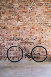 Bicycle at brick wall in office - HAPF02335