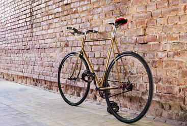 Bicycle at brick wall in office - HAPF02336