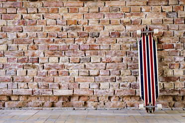 Longboard an Backsteinmauer im Büro - HAPF02337