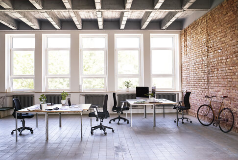 Coworking Space und Fahrrad an Backsteinmauer im Büro - HAPF02413