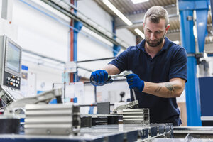 Mann arbeitet an einer Maschine in einer industriellen Fabrik - DIGF03121