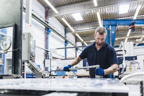 Mann arbeitet an einer Maschine in einer industriellen Fabrik - DIGF03123