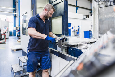 Man working on machine in industrial factory - DIGF03126