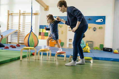 Vorschullehrerin hilft kleinem Mädchen beim Gehen auf Stufen - MFF04054