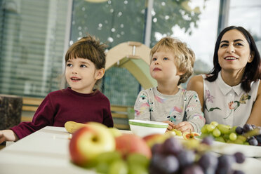Kinder und Lehrerin sitzen am Tisch mit Obst im Kindergarten - MFF04072