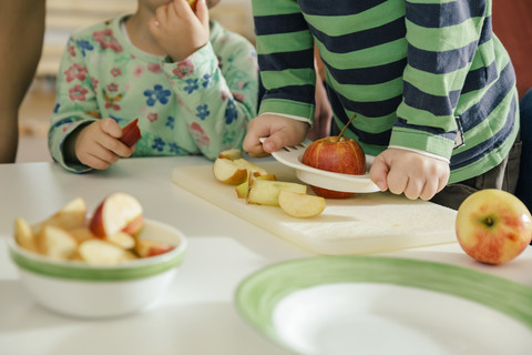 Nahaufnahme von Kleinkindern, die im Kindergarten Äpfel essen, lizenzfreies Stockfoto