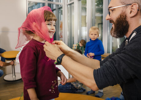 Vorschullehrerin bindet Kopftuch für Mädchen im Kindergarten - MFF04087