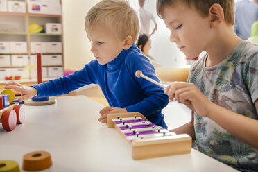 Zwei Jungen spielen mit Musikinstrumenten und Spielzeug im Kindergarten - MFF04089