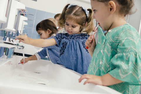 Children brushing their teeth in bathroom of a kindergarten stock photo