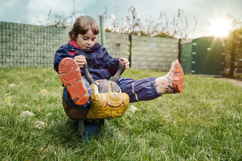 Girl rocking on wooden animal in garden of a kindergarten - MFF04112