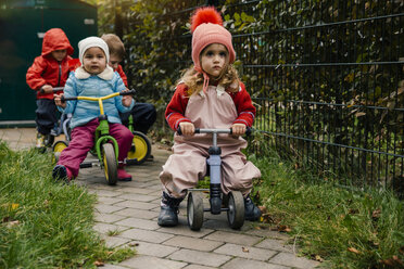 Kinder auf Rollern im Garten eines Kindergartens - MFF04115