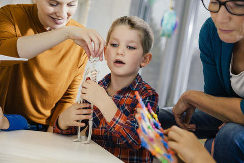 Junge und Vorschullehrer betrachten anatomisches Modell im Kindergarten, lizenzfreies Stockfoto