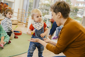 Vorschullehrerin spielt mit kleinem Jungen im Kindergarten - MFF04139