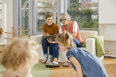 Vorschullehrer mit Tablet, die Kinder im Kindergarten beobachten - MFF04142