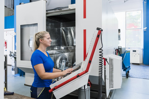 Woman operating control panel in industrial factory stock photo