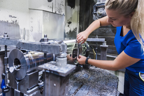 Frau arbeitet an einer Maschine in einer industriellen Fabrik - DIGF03148