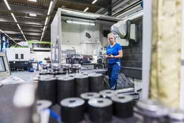 Woman standing in industrial factory - DIGF03149