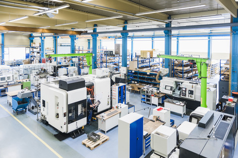 Mann, der eine Maschine in einer industriellen Fabrik bedient, lizenzfreies Stockfoto