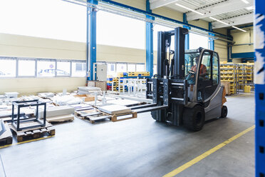 Man on forklift in factory warehouse - DIGF03164