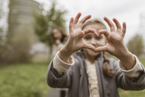 Girl shaping hands to a heart - KMKF00049