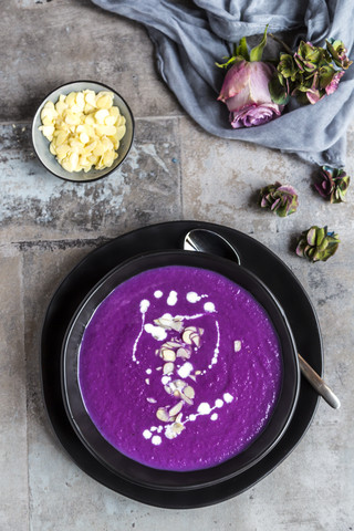 Schüssel mit Rotkohlsuppe, garniert mit Sahne und gehobelten Mandeln, lizenzfreies Stockfoto