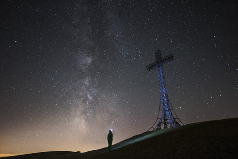 Italien, Marken, Silhouette eines Mannes mit Blick auf das Gipfelkreuz auf dem Monte Catria bei Nacht - LOMF00664