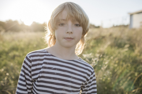 Porträt eines blonden Jungen im Gegenlicht, lizenzfreies Stockfoto