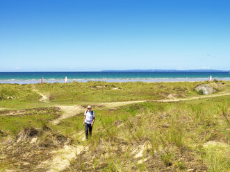 France, Bretagne, Active senior hiking on the beach of Treguer - LAF01930