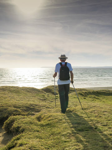 France, Bretagne, Active senior hiking on the beach of Treguer at sunset stock photo