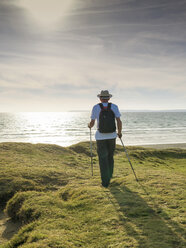 Frankreich, Bretagne, Aktive Senioren wandern am Strand von Treguer bei Sonnenuntergang - LAF01937