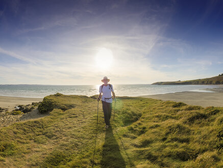 Frankreich, Bretagne, Aktive Senioren wandern am Strand von Treguer bei Sonnenuntergang - LAF01939