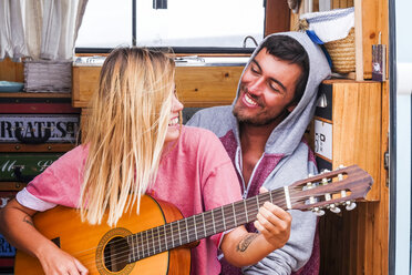 Young couple in love with guitar in a van - SIPF01837