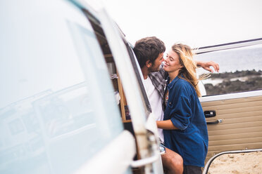 Spanien, Teneriffa, junges verliebtes Paar in den Ferien mit einem Lieferwagen am Meer - SIPF01840