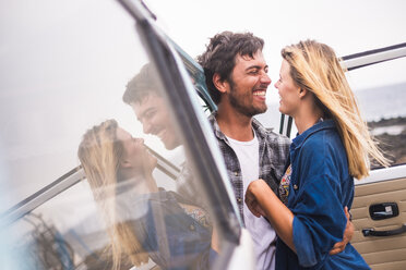 Spain, Tenerife, young couple in love on holidays with a van near the sea - SIPF01841