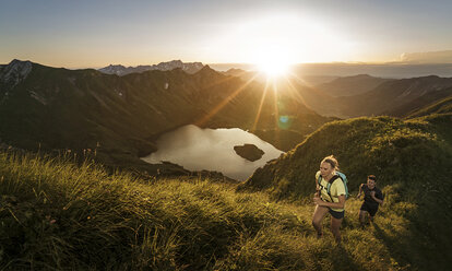 Deutschland, Allgäuer Alpen, Mann und Frau laufen auf Bergpfad - MALF00002