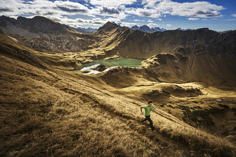 Deutschland, Allgäuer Alpen, Mann läuft auf Bergpfad, lizenzfreies Stockfoto