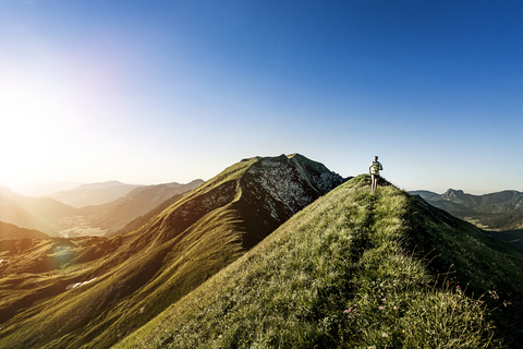 Deutschland, Allgäuer Alpen, Frau läuft auf Bergkamm, lizenzfreies Stockfoto