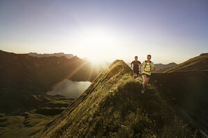 Deutschland, Allgäuer Alpen, Mann und Frau laufen auf Bergkamm - MALF00012