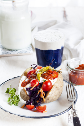 Kumpir, Turkish baked potato with raw vegetable salad, carrot, tomato, yogurt sauce, ajvar and Ayran stock photo