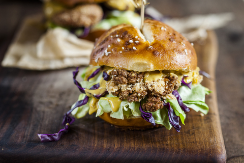 Vegetarischer Burger mit gebratenem Blumenkohl, Kopfsalat und Currysauce, lizenzfreies Stockfoto