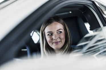 Smiling young woman in car - UUF12202