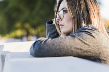 Thoughtful young woman leaning on a wall - UUF12227