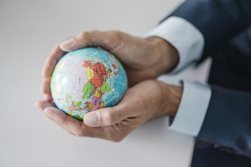 Close-up of hands of businessman holding globe - JOSF01829