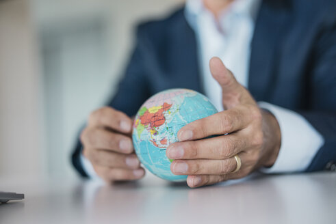 Close-up of hands of businessman holding globe - JOSF01830