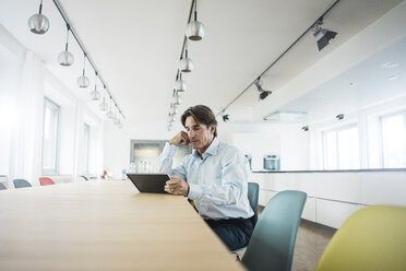 Geschäftsmann mit Tablet am Tisch im Büro - JOSF01847