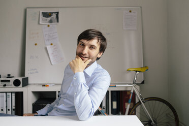 Portrait of smiling businessman at desk in office - BMF00842