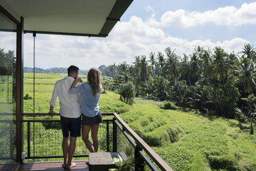 Couple standing on balcony, enjoying the landscape - SBOF00862