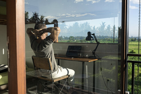 Mature man sitting at desk, looking at view - SBOF00878