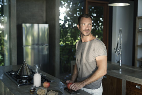 Mature man standing in kitchen, preparing healthy breakfast - SBOF00884