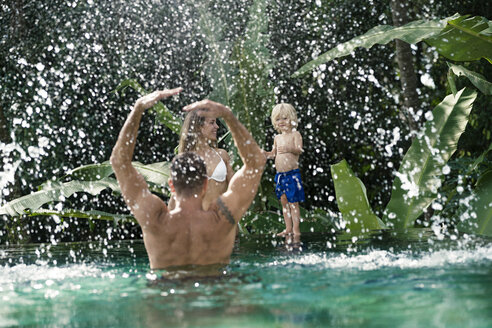 Glückliche Familie, die Spaß hat und im Sommer im Swimmingpool spielt - SBOF00904